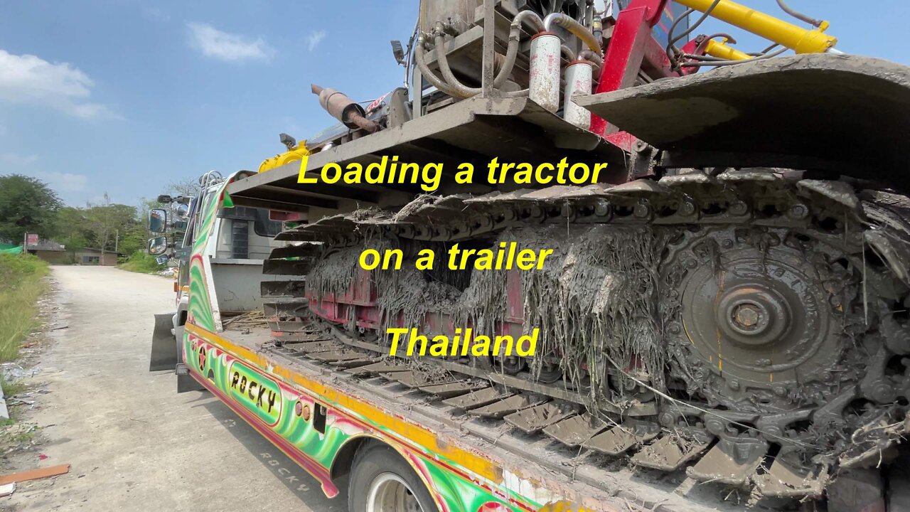 Loading a tractor on a trailer in Thailand