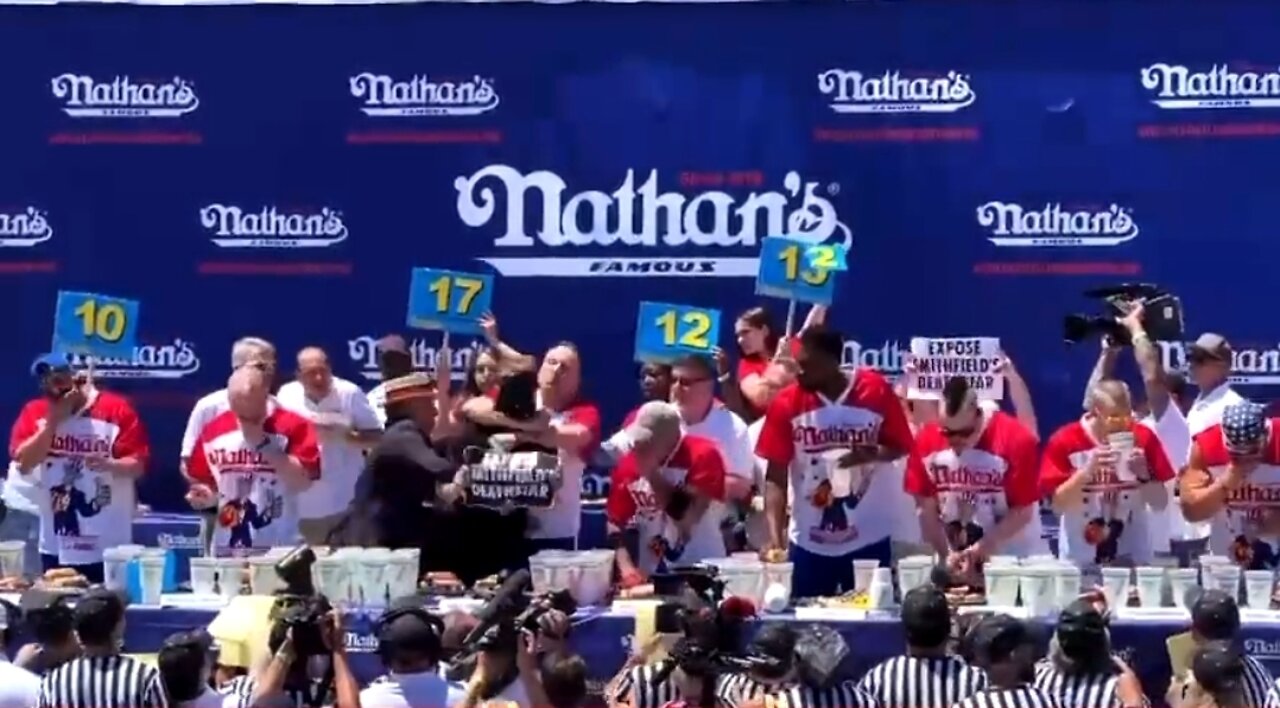 Joey Chestnut Puts Protestor In Head Lock At Hotdog Eating Contest