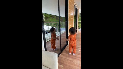 cute baby watching herself in the mirror