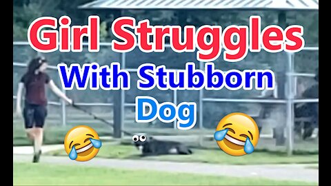 Girl struggles with stubborn dog