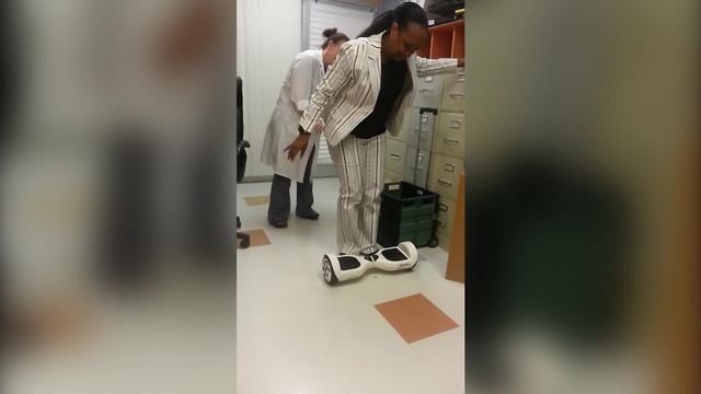 A Woman Struggles To Stand On A Self-Balancing Scooter