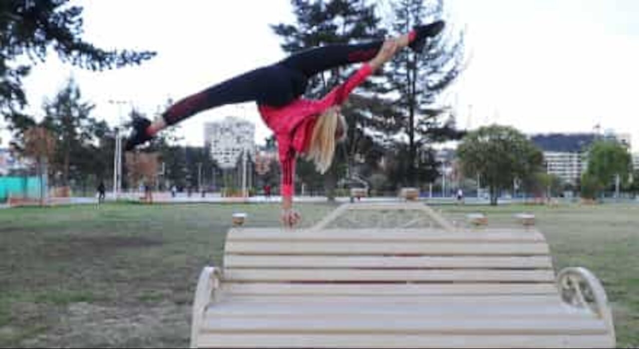 Ragazza fa acrobazie con una panchina del giardino