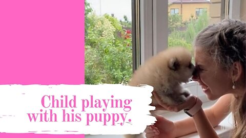 Child playing with his puppy.