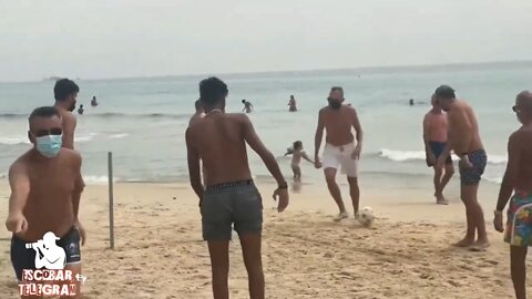 Italian men playing football on the beach with mask.