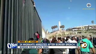 Migrants climb over border fence at Border Field State Park