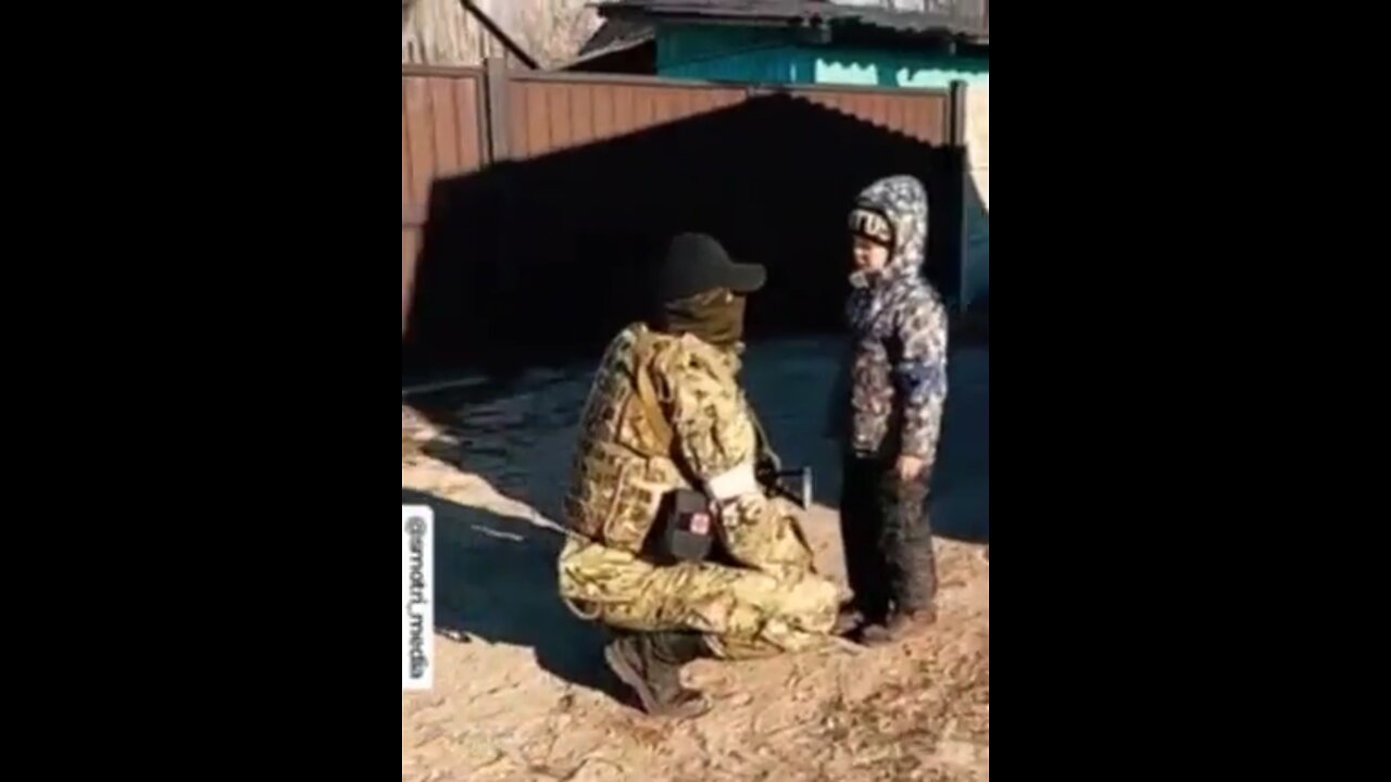 Hungry little boy is given rations by Chechen soldiers