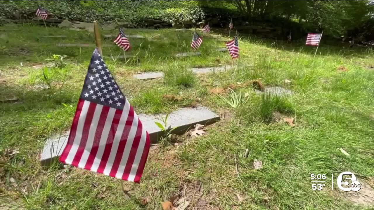 Volunteers begin the process of placing close to 9,000 flags on veterans' graves