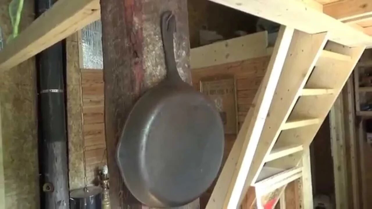 Antique Pots Hanging On Rustic Barn Wood Post In Tiny House