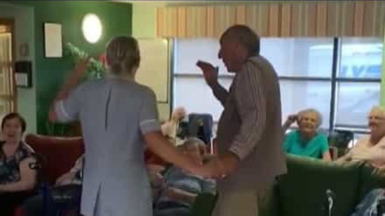 Caregiver dances the twist with nursing home resident