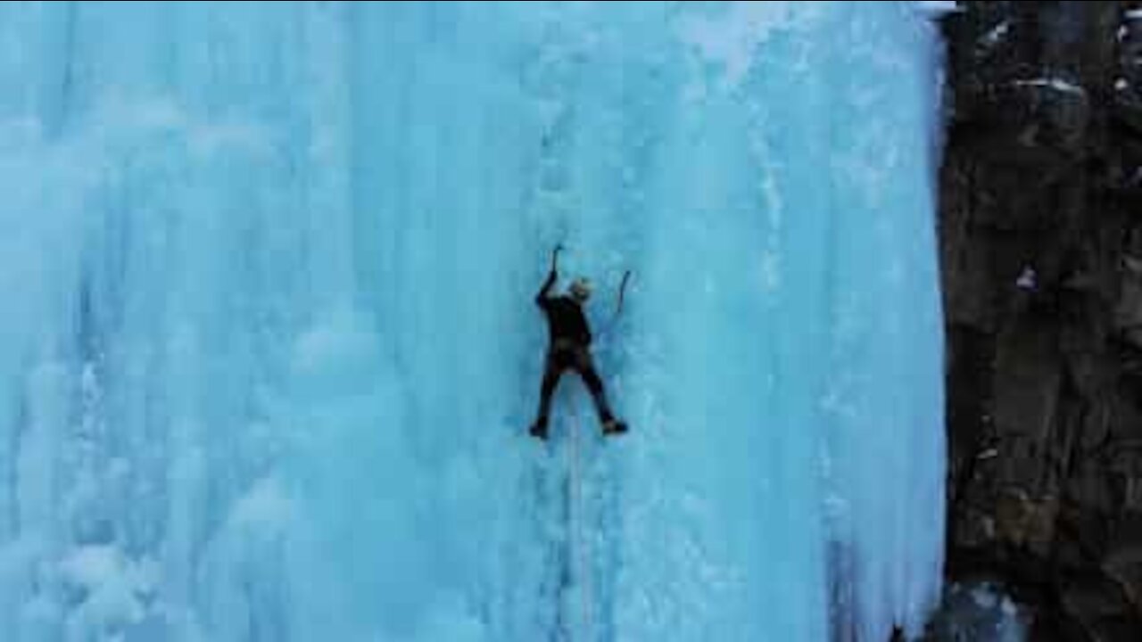 Alpinistas aventureiros escalam cascata congelada