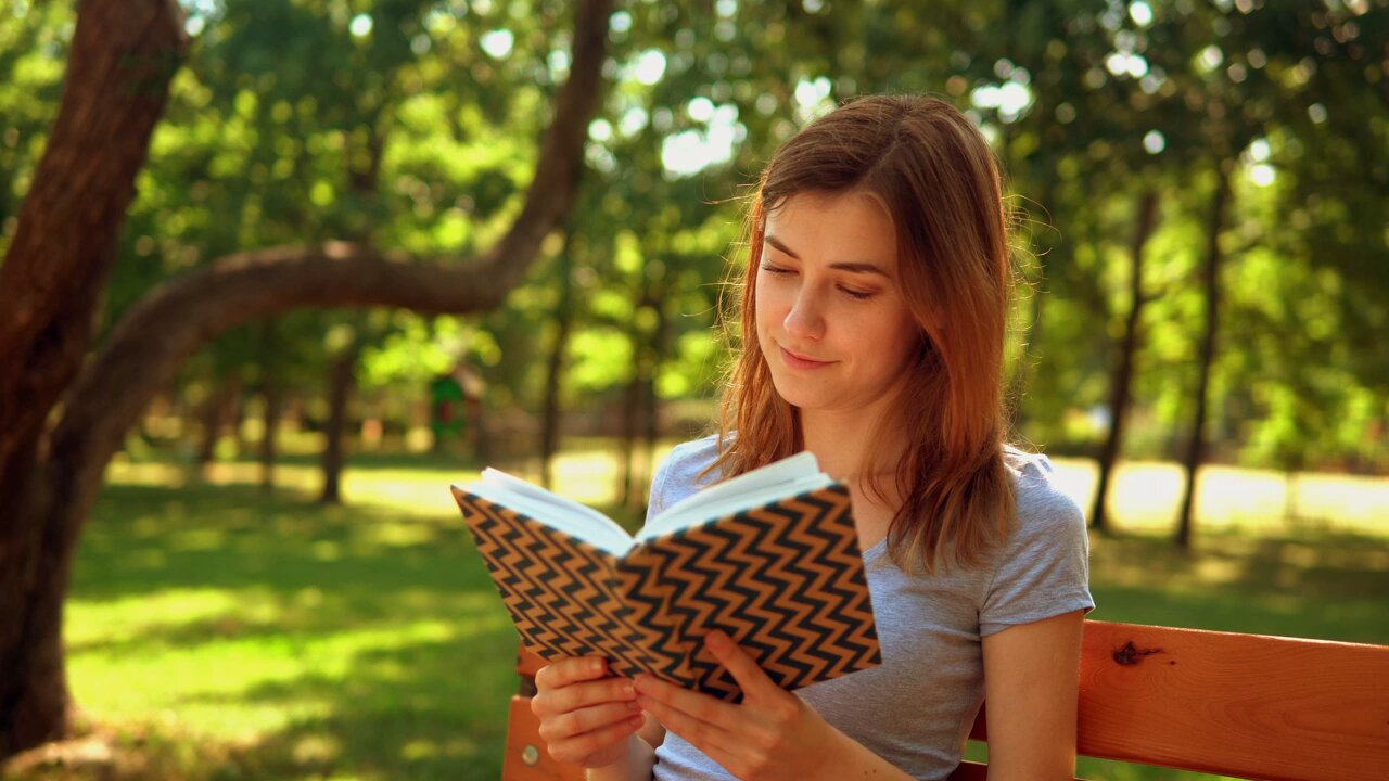 Girl reading a book in nature