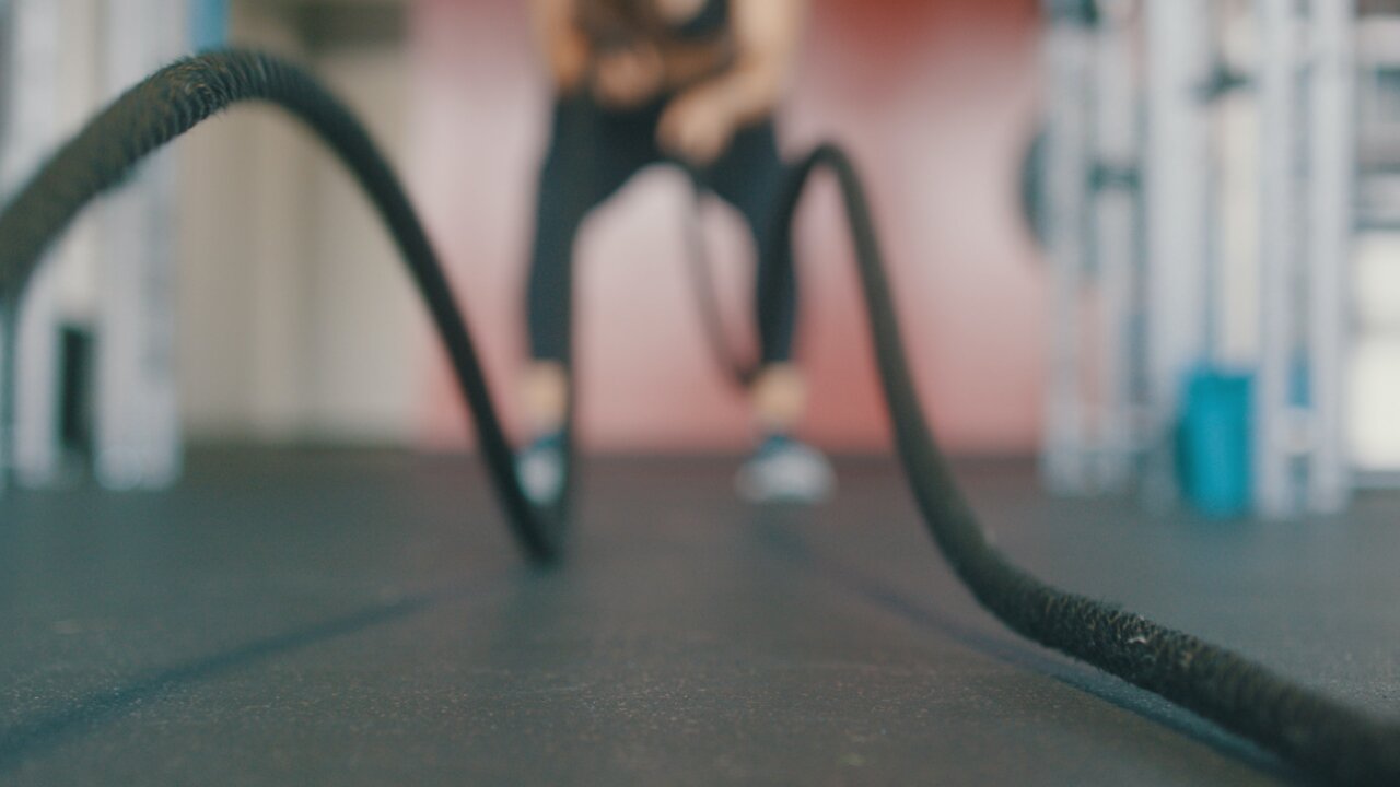 Girl does a series of barbell exercises at the gym