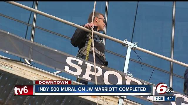 IndyCar driver Ed Carpenter helps put decal on JW Marriott downtown