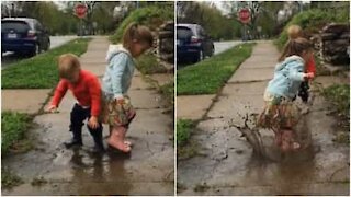 Bambini si divertono nella pozzanghera dopo la tempesta
