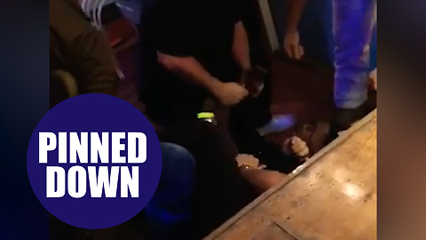 A black man was held down by five white security guards and elbowed in the face