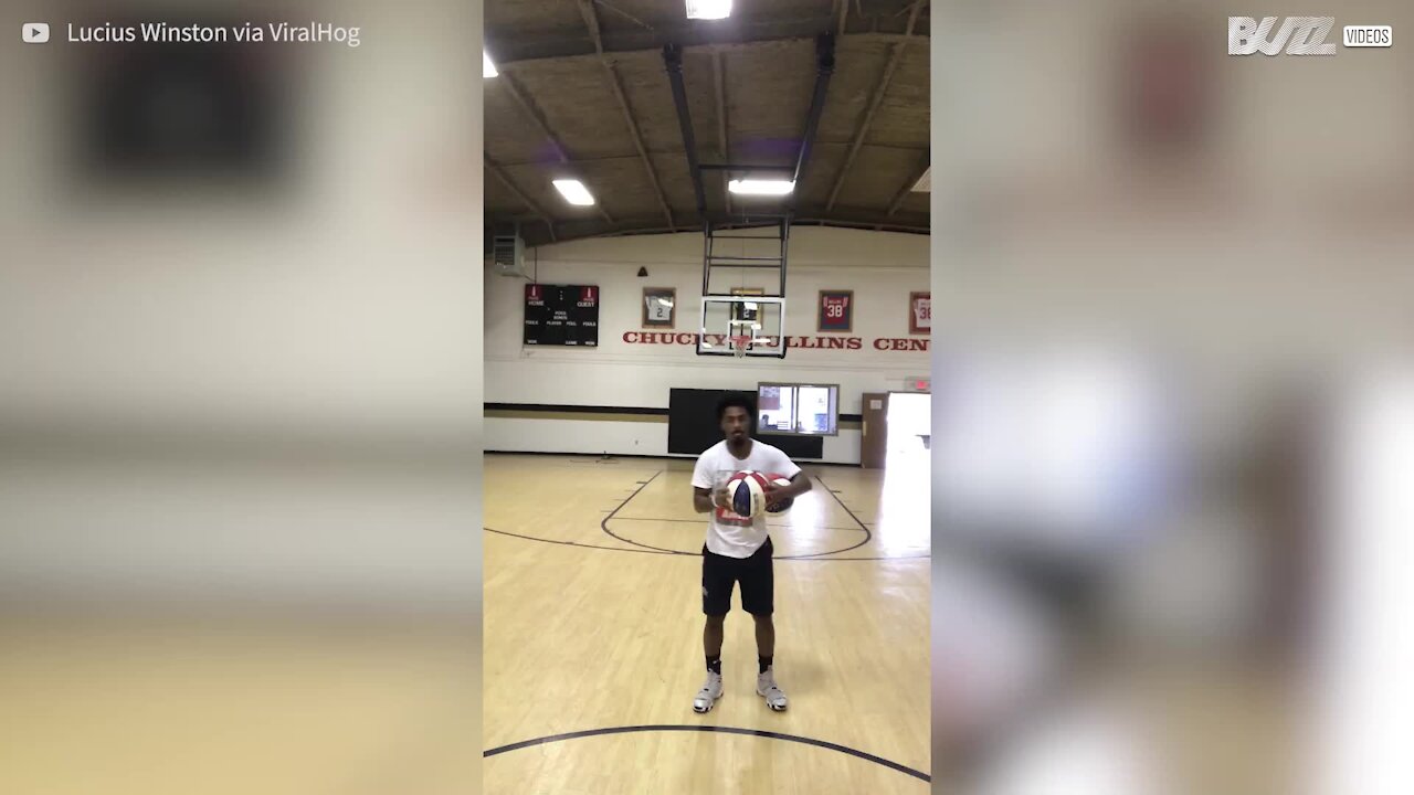 Ce basketteur marque dos au panier, avec deux ballons