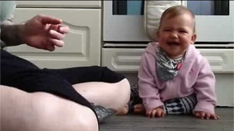 Baby bursts out laughing when mum plays with ball