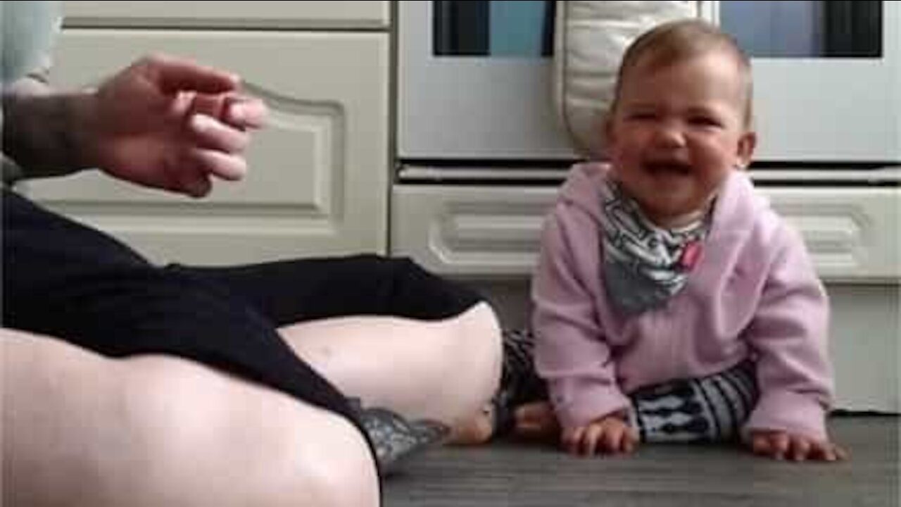 Baby bursts out laughing when mum plays with ball