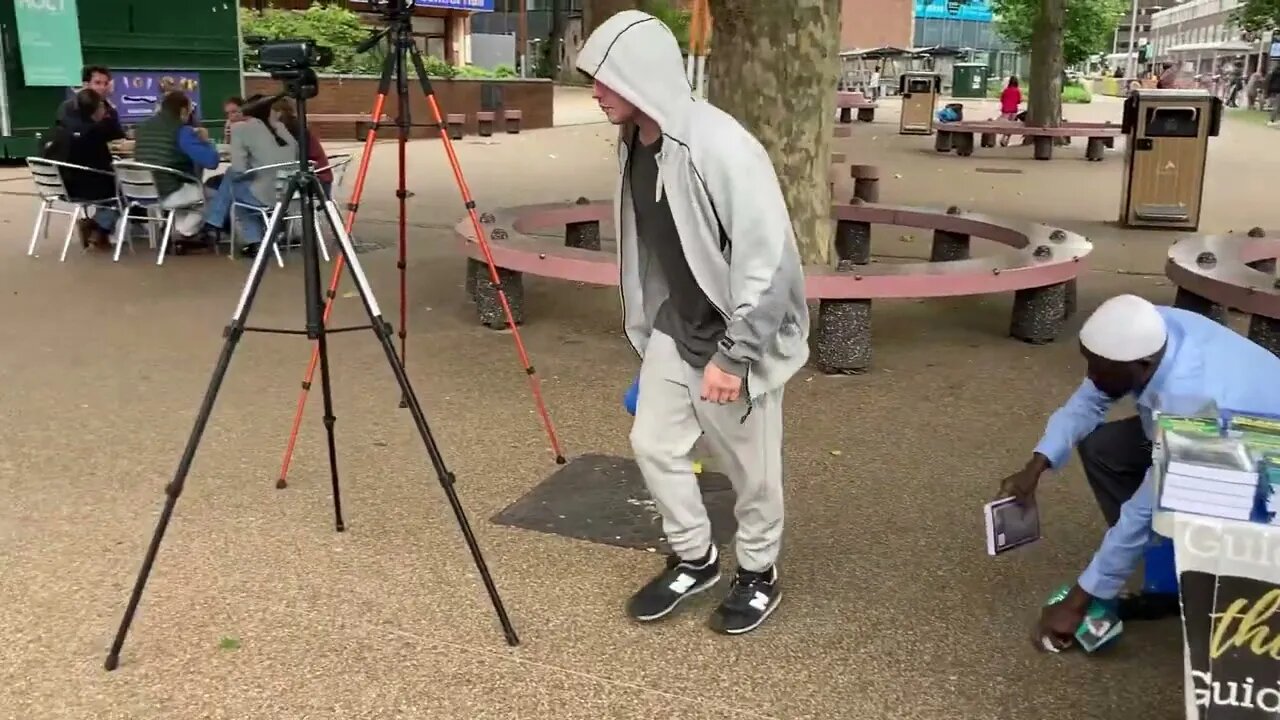 Hateful! He starts to put the Quran on the floor.