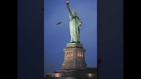 ufo passes by the statue of liberty
