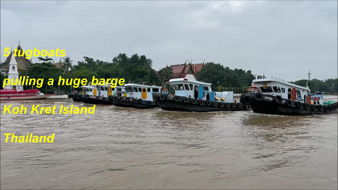 5 tugboats pulling a huge barge at the Chao Phraya River Koh Kret island Thailand