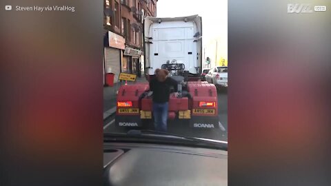 Un homme avec un masque d'ours grimpe sur un camion