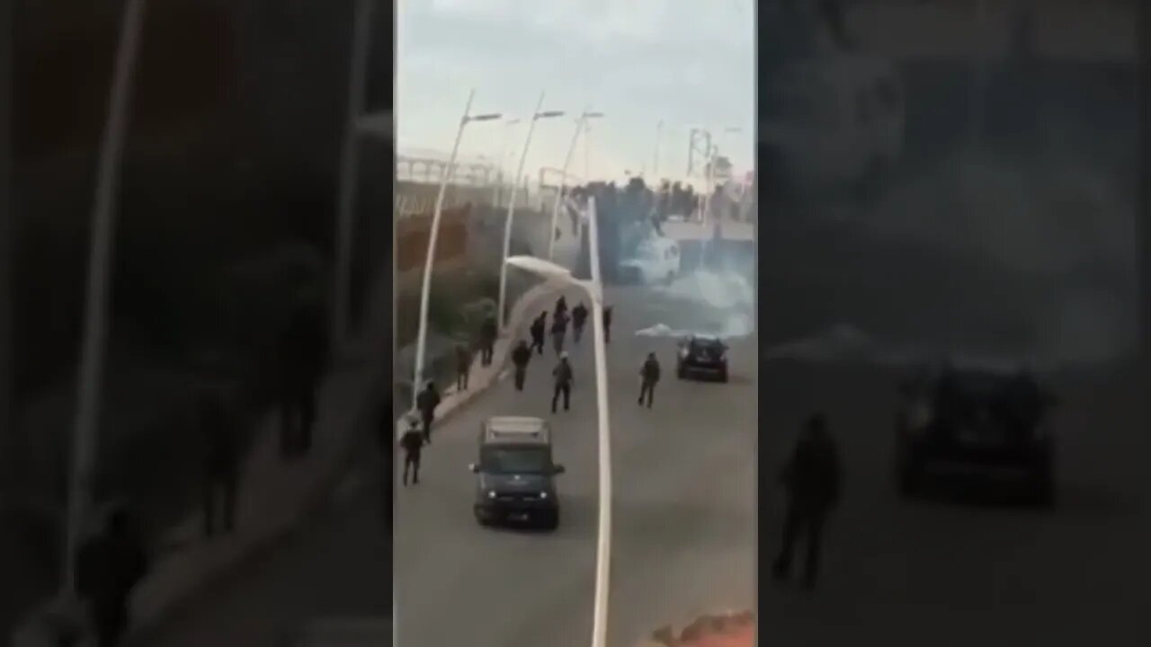 Migrants surge the crossing point by climbing walls and fell. Video filmed on the Moroccan side