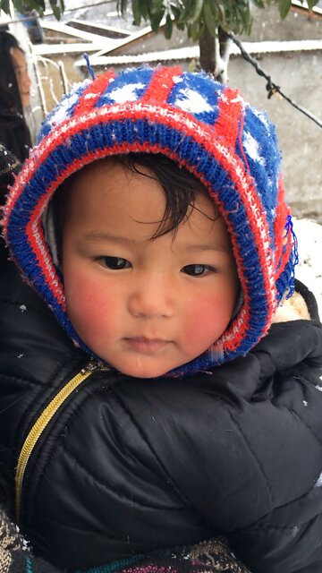 Cute baby enjoying snowboarding