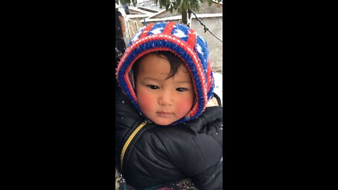 Cute baby enjoying snowboarding