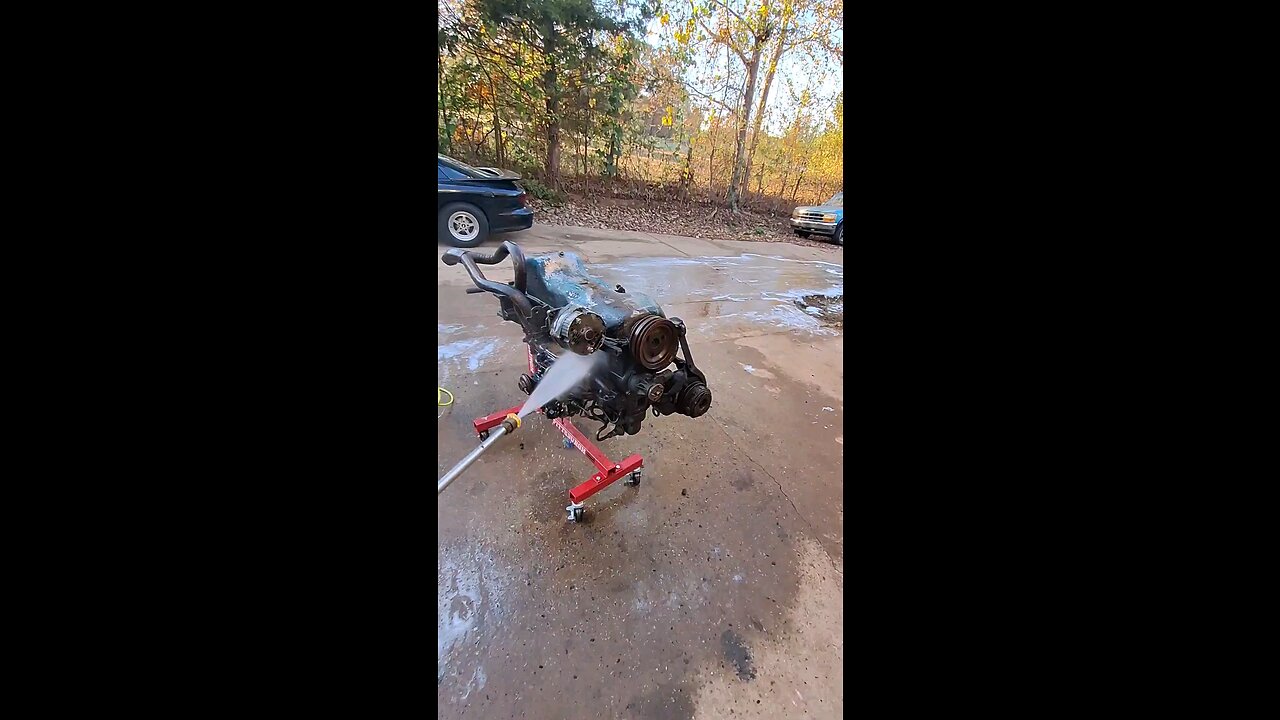 Cleaning a engine using a pressure washer.