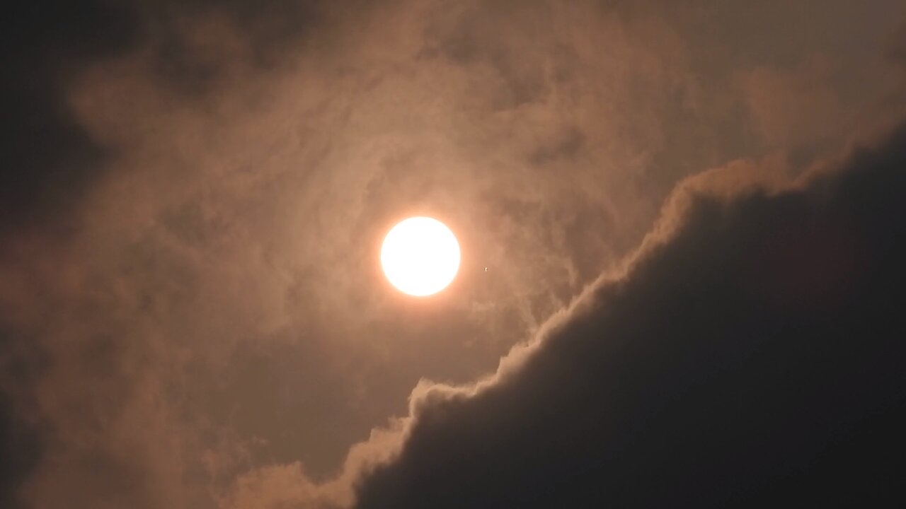 2023年4月13日下午在北新橋上拍攝雲層之間的太陽