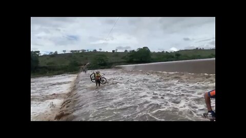 Guerreiros de bike atravessando a barragem de Jaguara transbordando