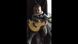 So cute! Baby plays guitar / ukulele