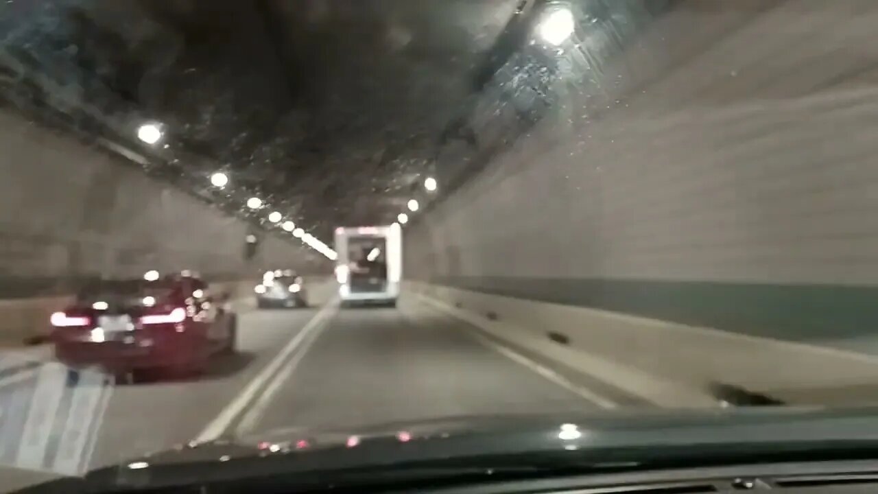 a truck driving through the tunnel with his door open