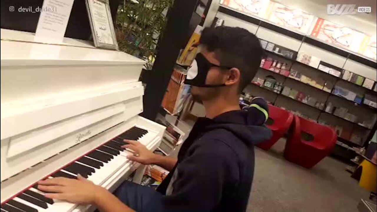 Un jeune homme joue du piano les yeux bandés