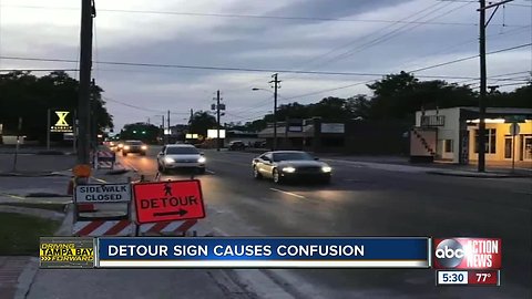 Photo calls out detour sign directing pedestrians to cross busy road