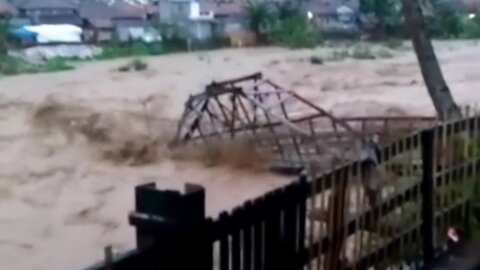 The bridge collapses when it is swept away by the flash flood