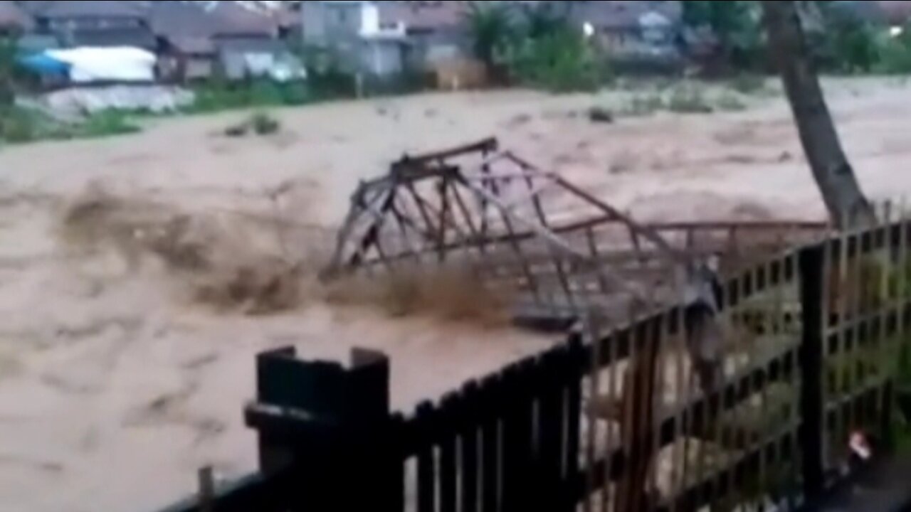 The bridge collapses when it is swept away by the flash flood