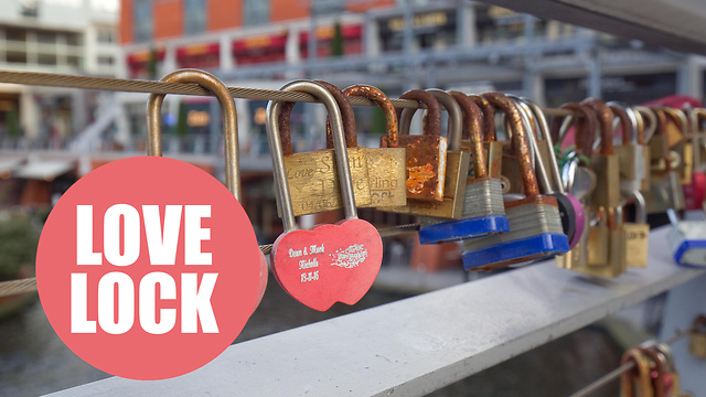 Romantic Brummies place padlocks on a bridge over a Birmingham canal