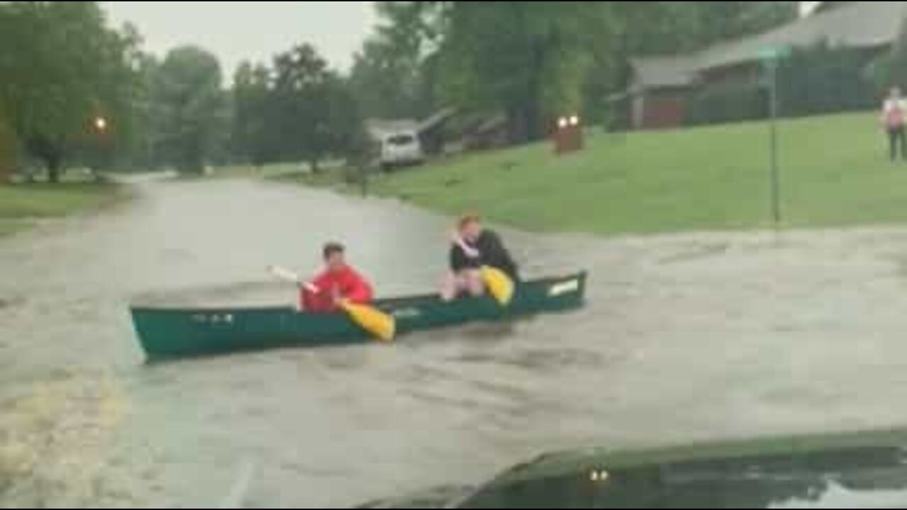 Deux jeunes profitent d'une tempête pour faire du canoë