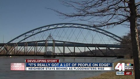 Neighbors stay behind as floodwaters rise