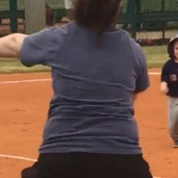 A Confused Baseball Playing Little Boy Runs To Give Mom A Hug