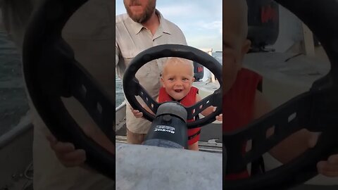 Driving daddy's boat and singing. Outdoor Johnny