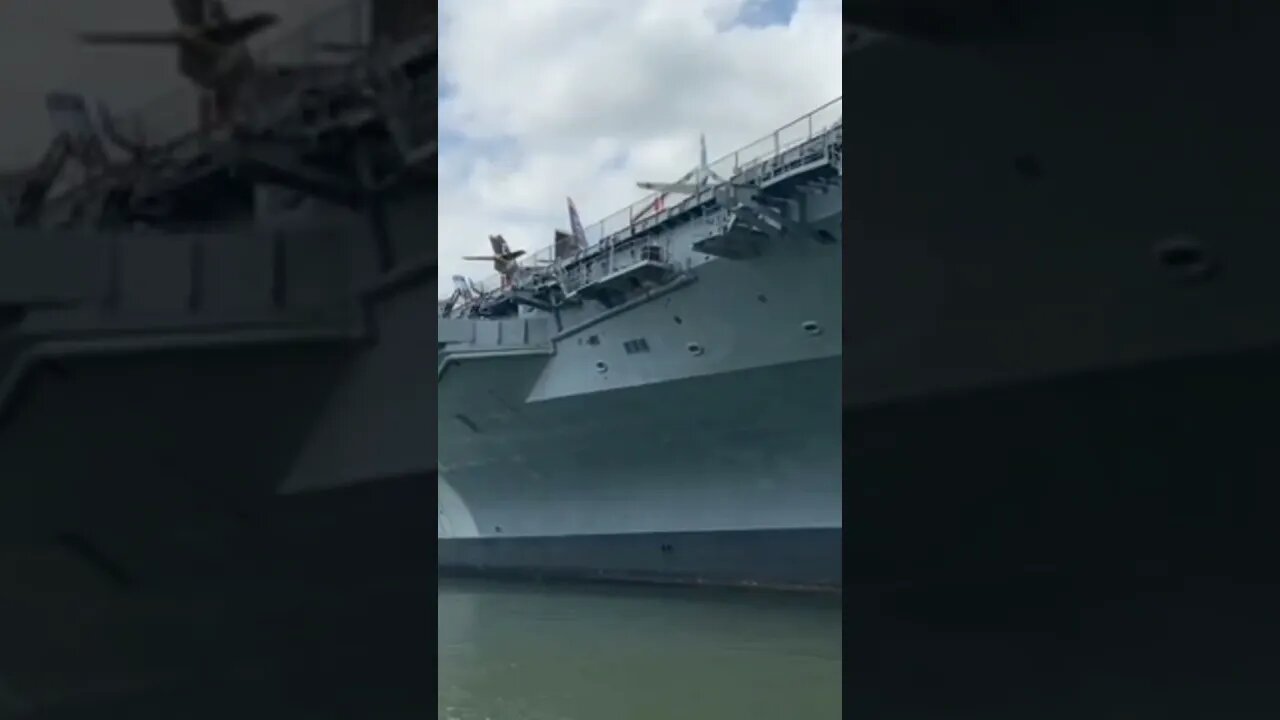 An Aircraft Carrier Docked In The Sea Bay