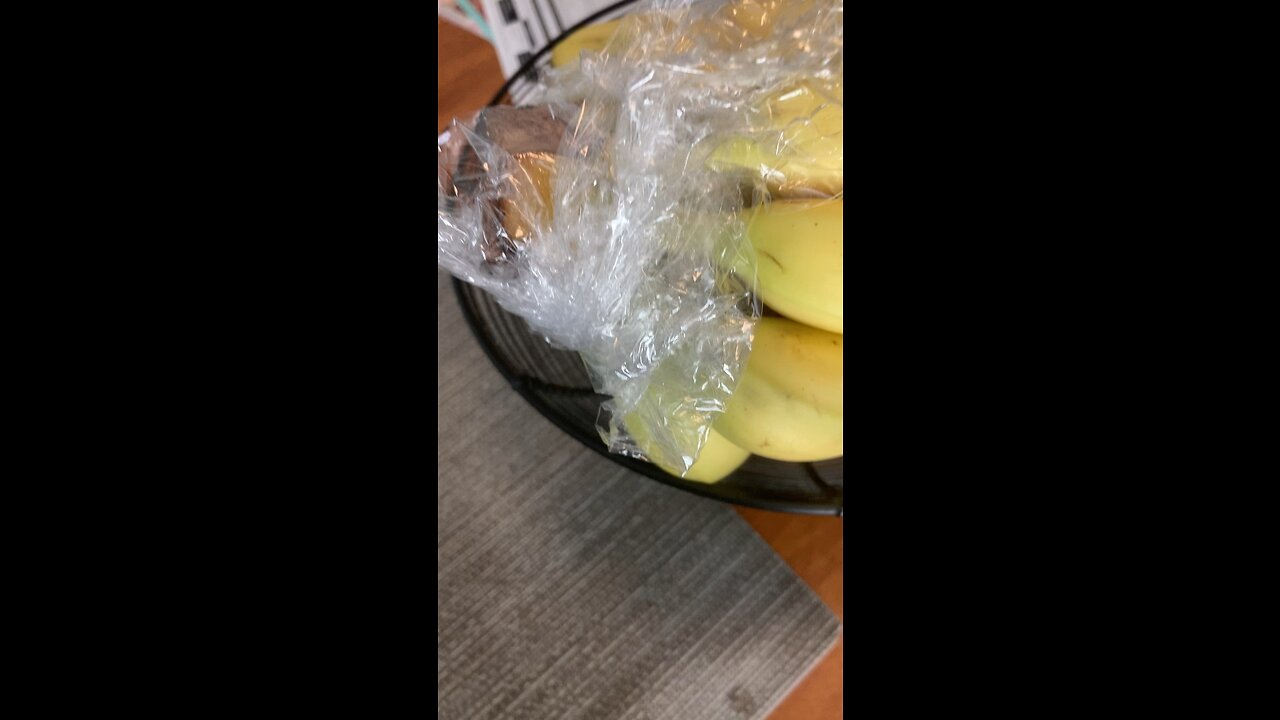 Wrapping banana stems in cling wrap for freshness