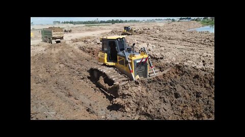 Work on the lake filling with dump truck spreading mud Extreme