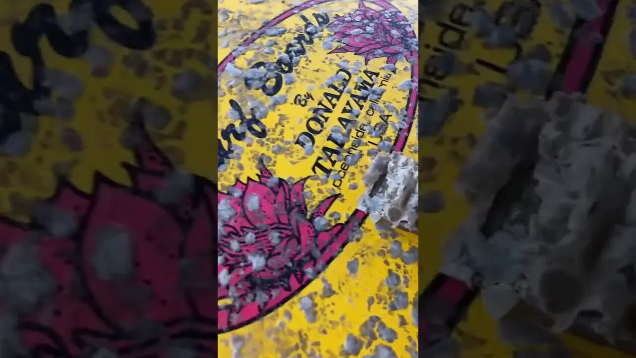 Scraping wax off a surfboard