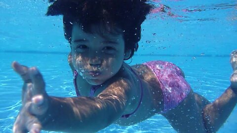 Fearless toddler small baby swimming with dad