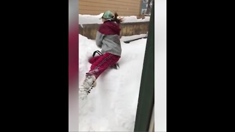 Girl is completely engulfed in snow after jumping into massive pile