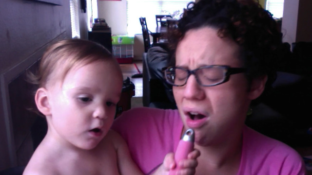 A Mom And Her Toddler Lip Sync With A Hair Brush